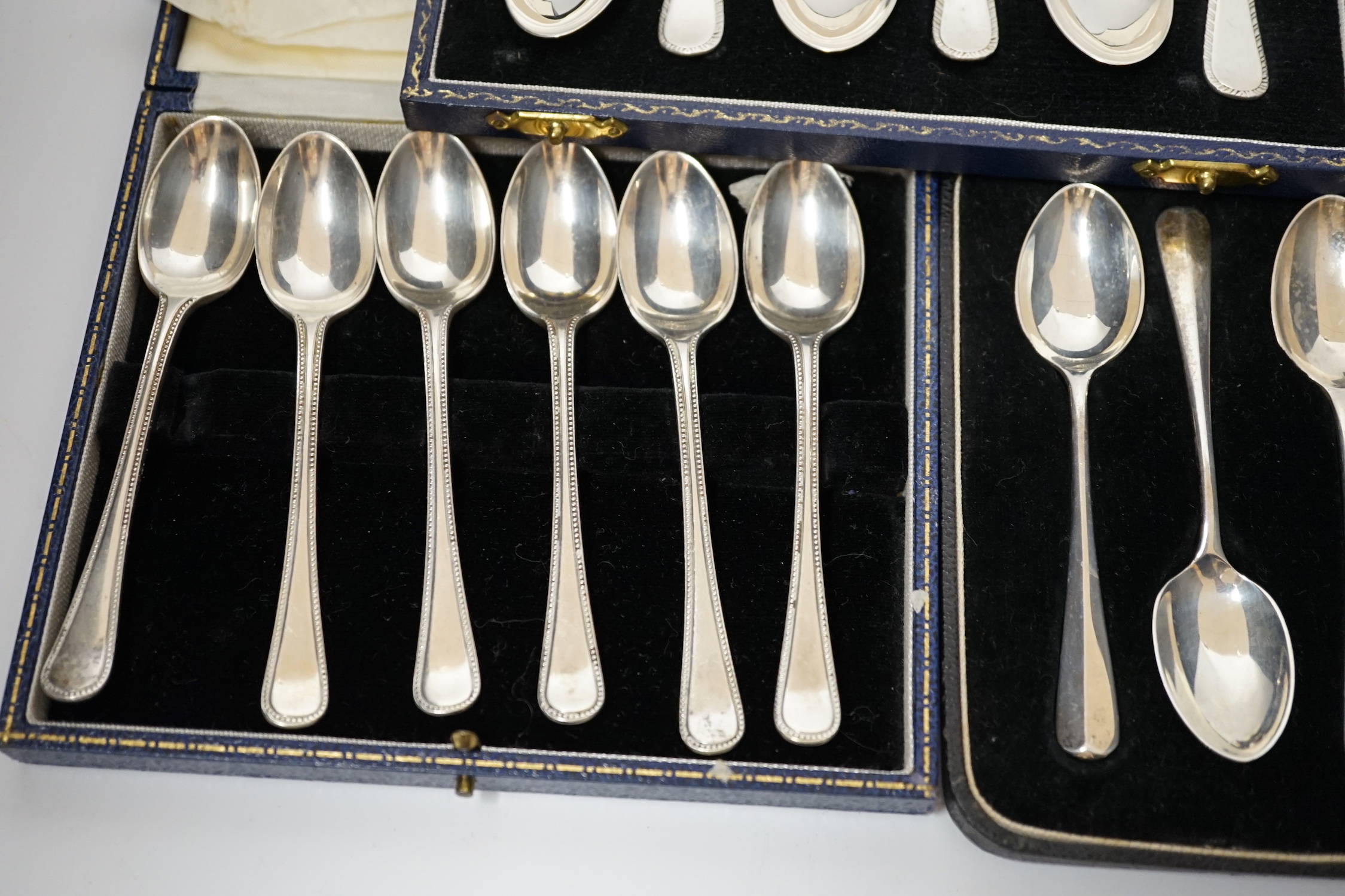 Three assorted cased sets of six silver tea or coffee spoons including Old English feather edge pattern.